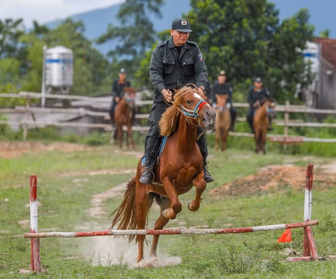 A soldier is with his horse performing a barrier-crossing maneuver.. At the Horse-Mounted Police Squad’s training centers, all jobs from cleaning, feeding horses to taking care of horse health are done by well-trained police officers with supports from experts and veterinarians.