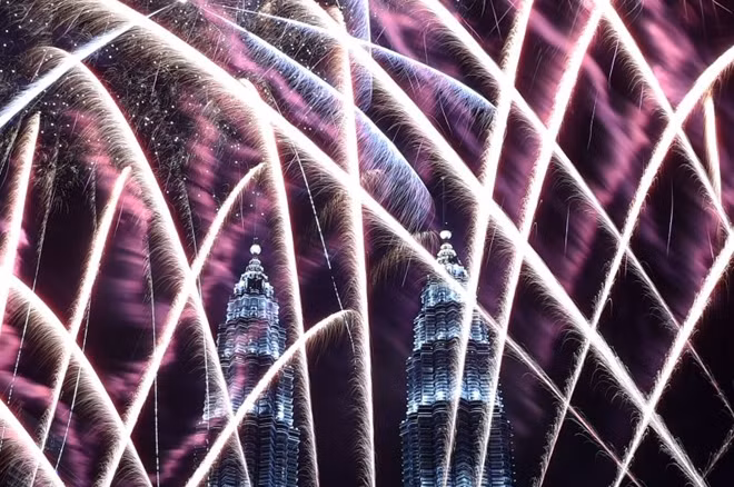 Fireworks illuminate the sky near Malaysia's Petronas Twin Towers during New Year celebration in Kuala Lumpur