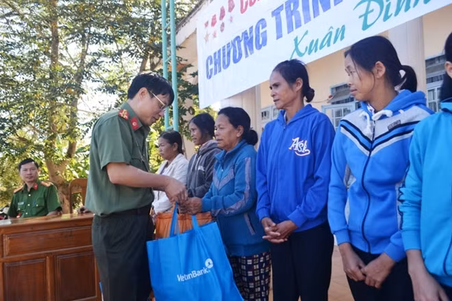 Colonel Pham Khai, Deputy Editor in Chief of the Public Security Newspaper presenting Tet gifts to needy families