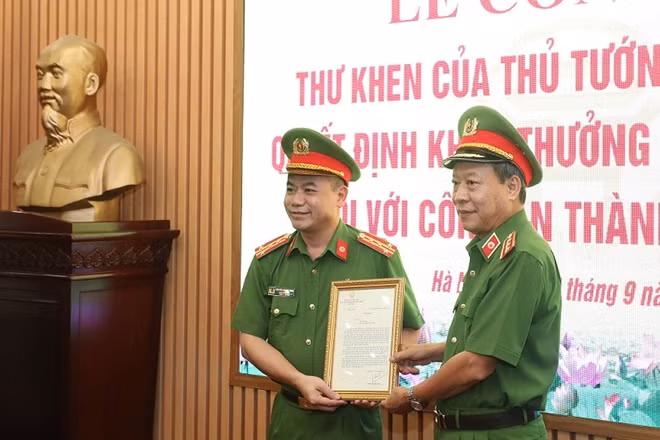 Deputy Minister Le Quy Vuong hands the letter of commendation from the Prime Minister to the Hanoi police.