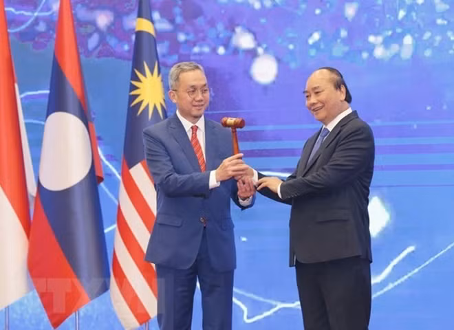 Prime Minister Nguyen Xuan Phuc (R) hands over a gavel to the Ambassador of Brunei to Vietnam, as his country will hold the role as ASEAN Chair in 2021. (Photo: VNA)