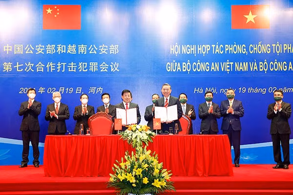 The two ministers sign the agreement.
