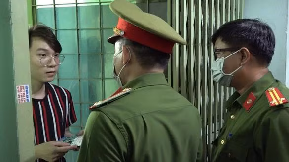 Police officers distribute leaflets about COVID-19 control and prevention to residents living in Mieu Noi Apartment Building Complex in HCM City’s Binh Thanh district (Photo: tuoitre.vn)