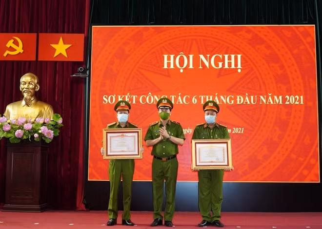 Deputy Minister Le Quoc Hung hands the Certificates of Merit awarded by the Prime Minister to outstanding individual and team.