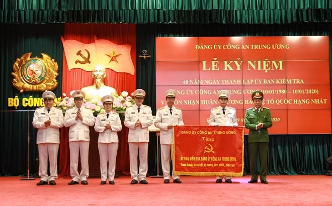 Deputy Minister Le Quy Vuong presents a lacquered board with engraved words “Trung thành, đoàn kết, kỷ cương, liêm khiết, hiệu quả” (Loyalty, Solidarity, Discipline, Probity and Efficiency) to representatives of the commission.