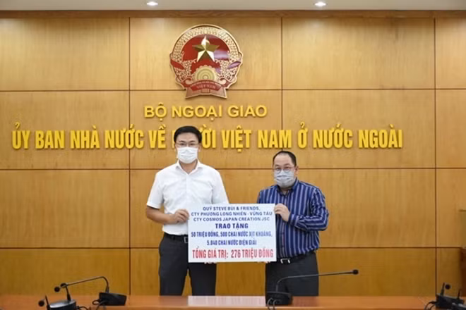 Deputy Foreign Minister Pham Quang Hieu (left) receives money and medical supplies from overseas businesses in support of COVID-19 fight at home (Photo:qdnd.vn)
