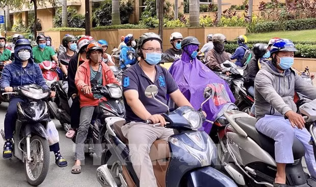 People wear masks while driving in HCM City (Source: VNA)