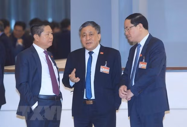 Delegates discuss before the session on January 29 morning (Photo: VNA)