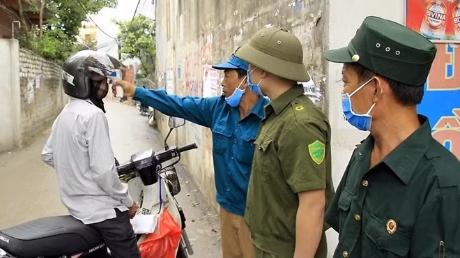 Members of a team check the temperature of a person.