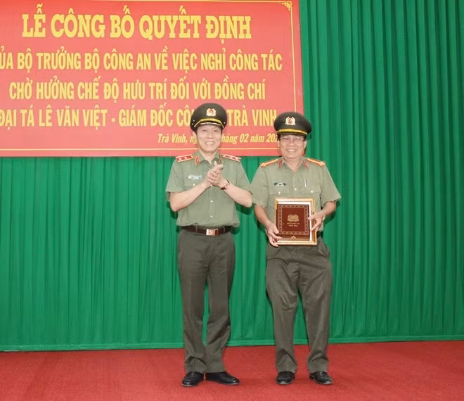 Deputy Minister Luong Tam Quang handed the Retirement Decision to Senior Colonel Le Van Viet.