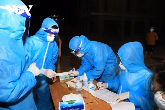 Healthcare workers in Nghe An (central Vietnam) work overnight to take samples for COVID-19 testing.