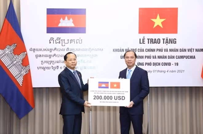 Presenting the Vietnamese gift to Cambodian Ambassador to Vietnam Chay Navuth, Deputy Foreign Minister Nguyen Quoc Dzung (R) hopes the gift will partly help Cambodia combat the COVID-19.