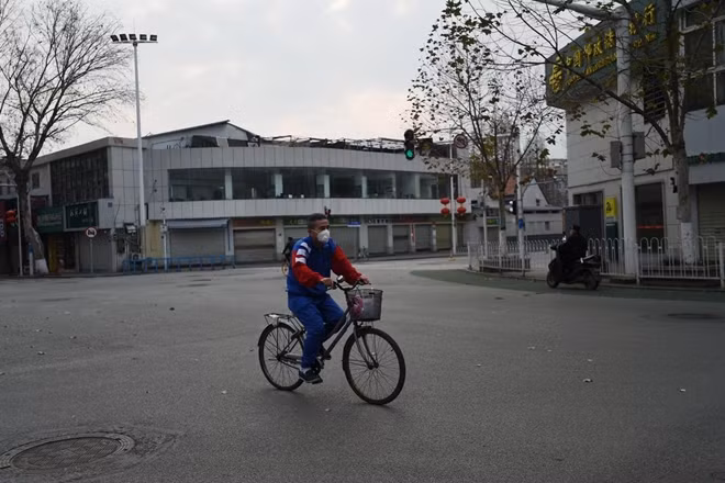 A man wearing a face mask rides a bicycle in Wuhan, the epicentre of the novel coronavirus outbreak, Hubei province, China February 24, 2020. REUTERS/Stringer