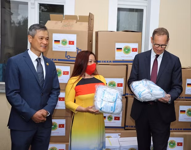 Duong Thi Bich Ngoc (centre), head of the Sen Vang charity organisation, presents the gifts to Governing Mayor of Berlin Michael Müller (R). Vietnamese Ambassador Nguyen Minh Vu stands on the left.(Photo: VNA)