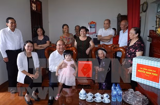 Prime Minister Nguyen Xuan Phuc (holding the baby) visits Vietnam Heroic Mother Tran Thi Phi in Ninh Binh (Photo: VNA)