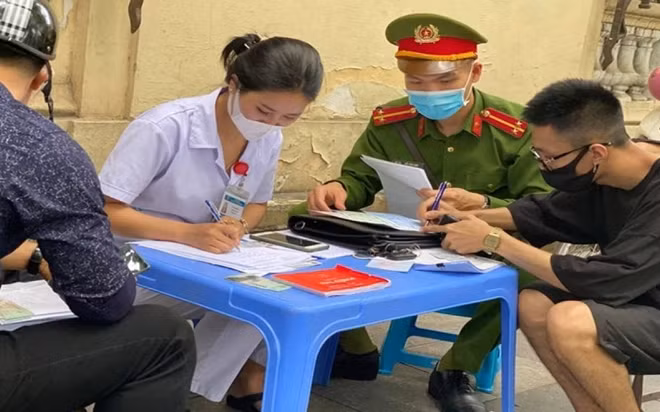 A coronavirus checkpoint in Hanoi's Hoan Kiem district asks people to wear masks in public. Photo: Hai Nam