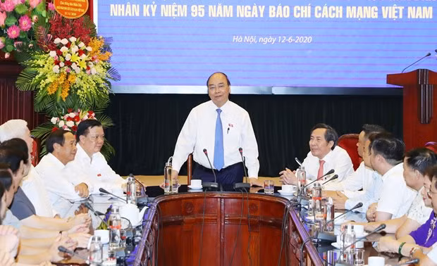 Prime Minister Nguyen Xuan Phuc (standing) speaks at the meeting with the Nhan dan newspaper's leaders and staff on June 12 (Photo: VNA) Prime Minister Nguyen Xuan Phuc (standing) speaks at the meeting with the Nhan dan newspaper's leaders and staff on June 12 (Photo: VNA)