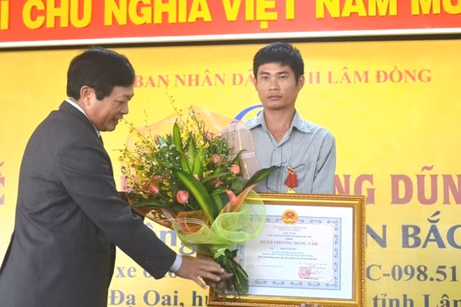 Mr. Đoàn Văn-President of People's commitee of Lâm Đông province deserved The Heroic Cross to Driver Phan Văn Bắc (Photo: Kim Ngân)