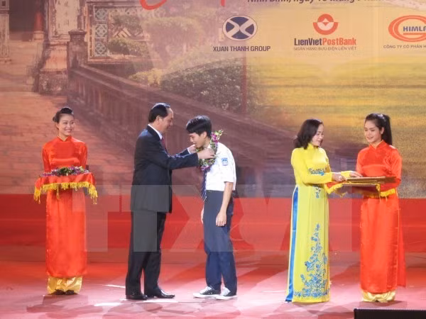 President Tran Dai Quang (second, left) presents a reward to a student (Photo: VNA)