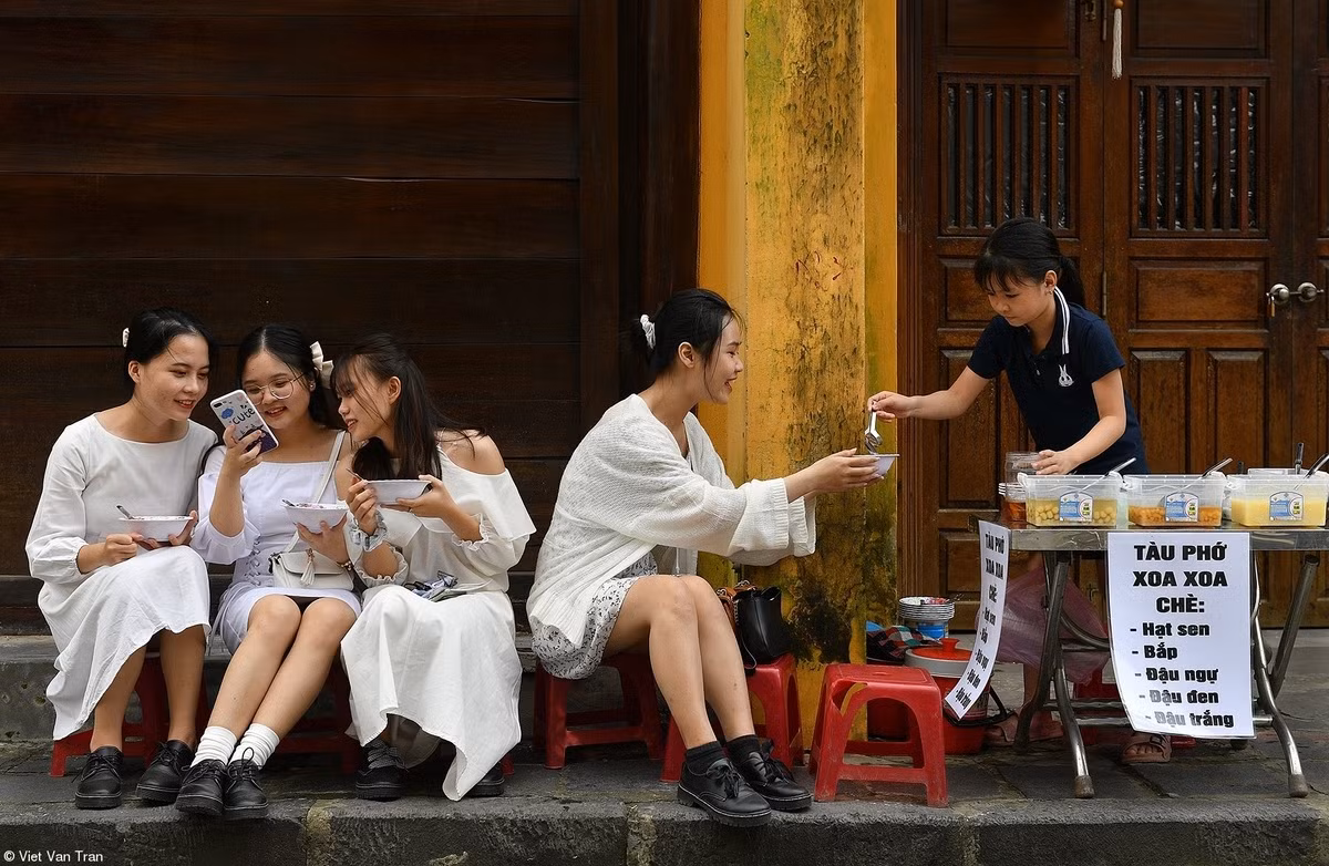 Vietnamese photographers claim first prizes in UK photo contest ảnh 3 Elsewhere in the competition, Tran Viet Van’s work featuring four young girls enjoying che, sweet soup, on a street in Hoi An, a globally-renowned UNESCO world heritage site and leading tourist destination, claimed the first prize in the Street Food category.