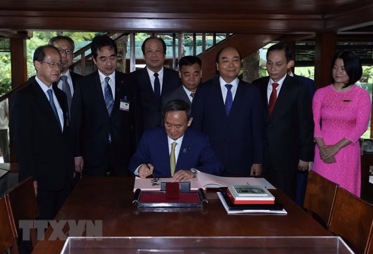 PM Suga signs the guestbook at the President Ho Chi Minh relic site.