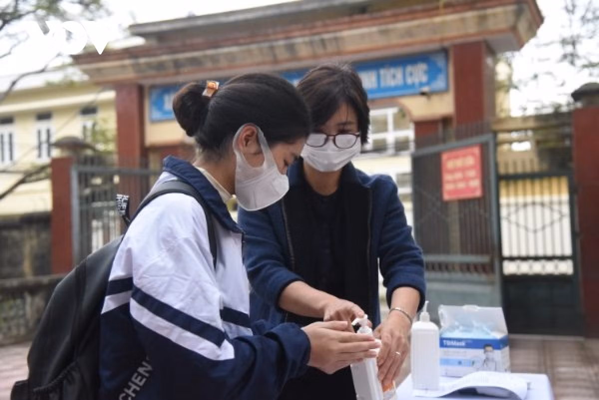 Hanoi schools reopen to ninth graders across 17 suburban districts ảnh 12 Students have their body temperature checked and thoroughly disinfect their hands at the school’s gate.