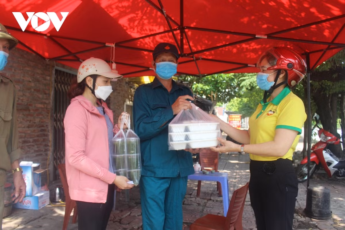 A haul of free meals are handed over to frontline workers at a COVID-19 checkpoint located in Ha Dong district.