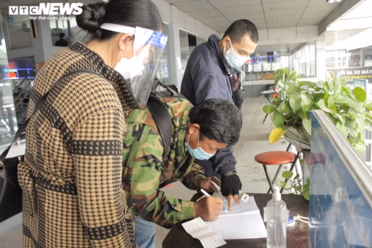 Hanoi bus stations fall quiet as Tet draws very near ảnh 3 Passengers are required to complete health declarations before being permitted to board the bus.