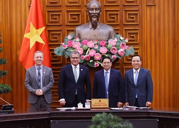 Prime Minister Pham Minh Chinh (second, right), British Cabinet Minister and COP26 President Alok Kumar Sharma (second, left), and other officials pose for a photo at the meeting in Hanoi on February 14 (Photo: VNA)