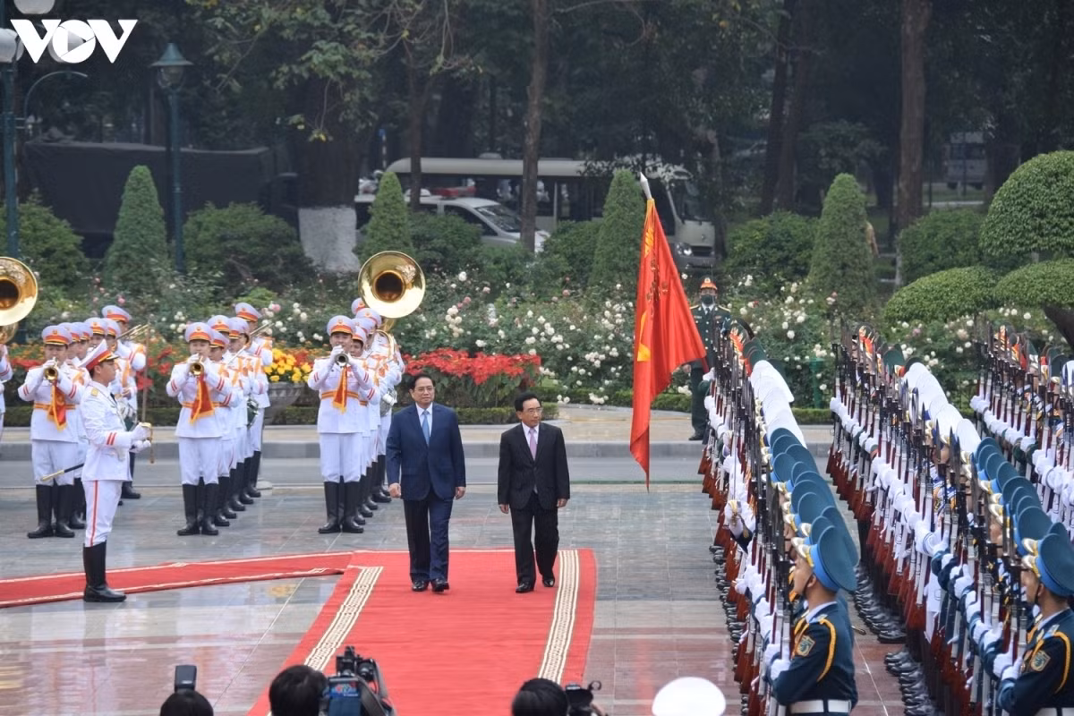 Highlights of Laos PM’s visit to Vietnam in photos ảnh 2 The visit takes place at a time when the great friendship, special solidarity, and comprehensive co-operation ties between both sides have been firmly consolidated and deepened in all fields. In the photo, the two PMs review the guard of honour in Hanoi.
