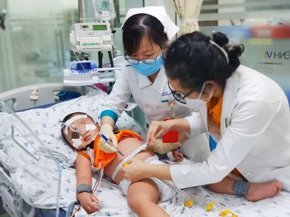 Dengue fever cases show signs of increase in Vietnam ảnh 1 Medical workers is treating a severe child patient infected with dengue fever. Photo: Liberated Saigon (Saigon Giai Phong (SGGP)