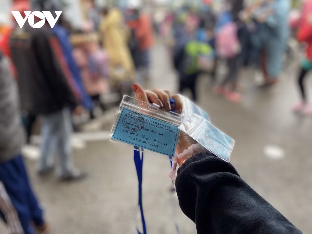 Hanoi kids return to school after nine months of online learning ảnh 3 First graders are given a card with their name, class name and class address on it.