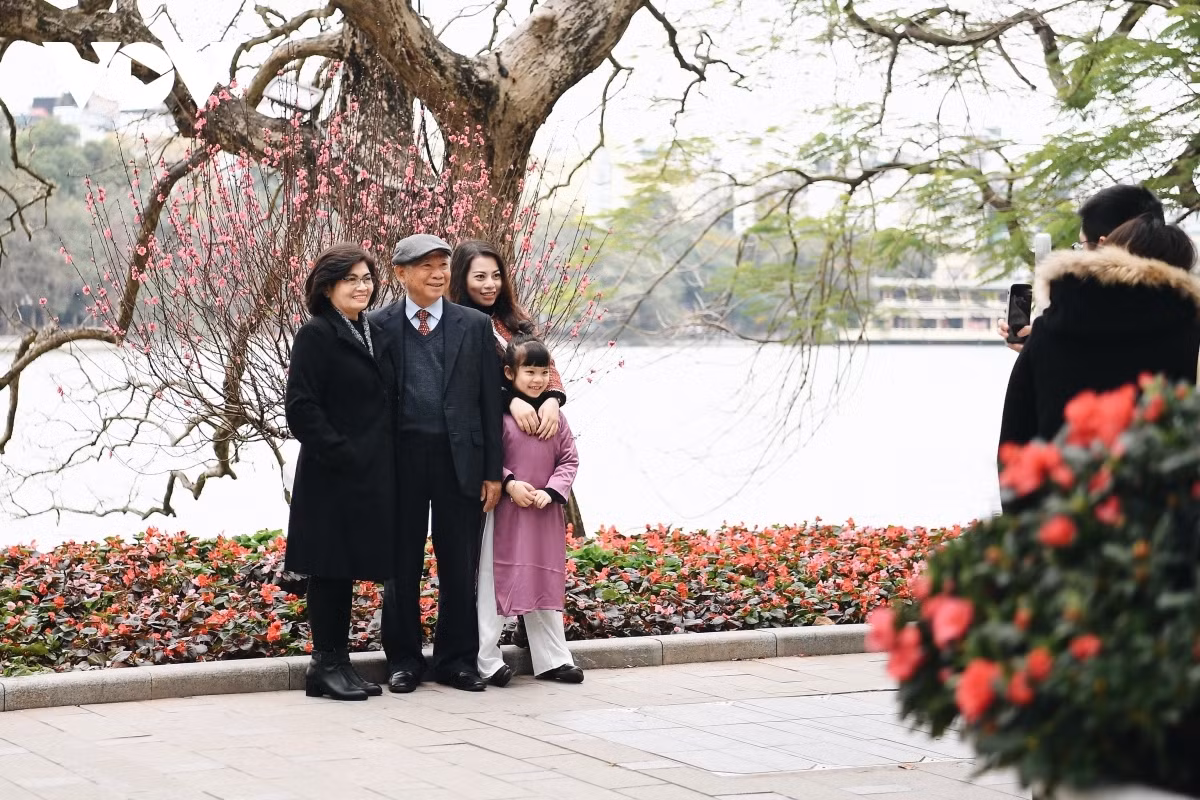 Peaceful and tranquil Hanoi on first day of Lunar New Year ảnh 10 A family enjoys the peaceful and pleasant atmosphere as the surroundings of the Hoan Kiem iconic lake city are left totally quiet and deserted.