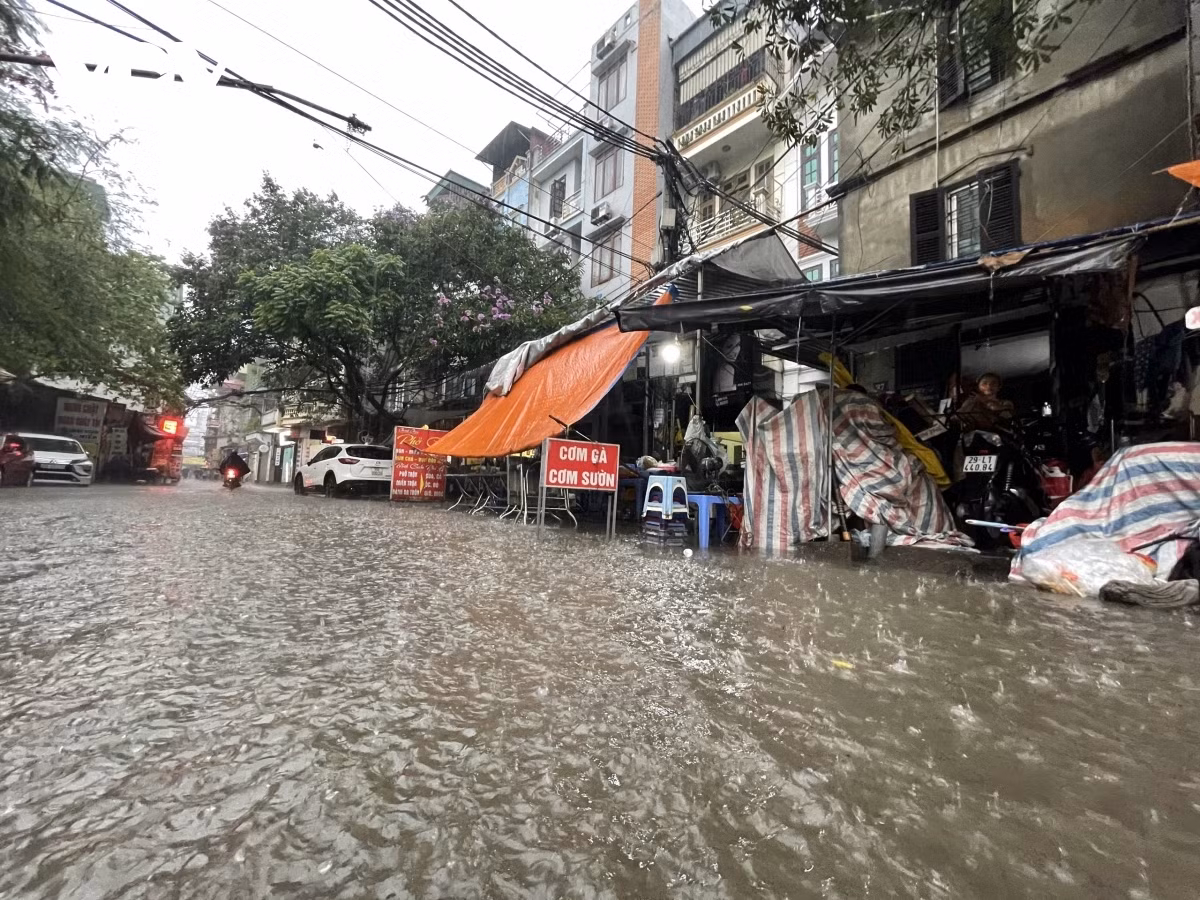 Many local traders on both sides of the road have to move tables and chairs to higher places to avoid being swept away by violent water flows.