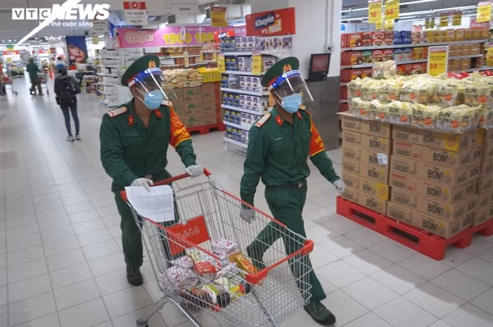 Military forces help locals shop amid tighter restrictions in HCM City ảnh 2 Many soldiers head to the supermarket in the early morning so they can buy essential food for residents in District 7.