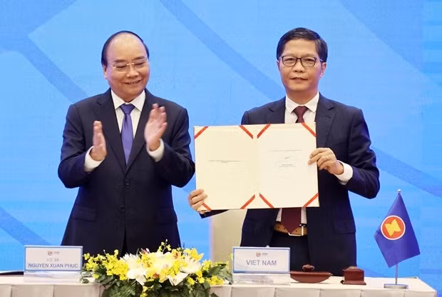 Prime Minister Nguyen Xuan Phuc (L), as Chair of ASEAN in 2020, witnesses the signing of the Regional Comprehensive Economic Partnership (RCEP) agreement