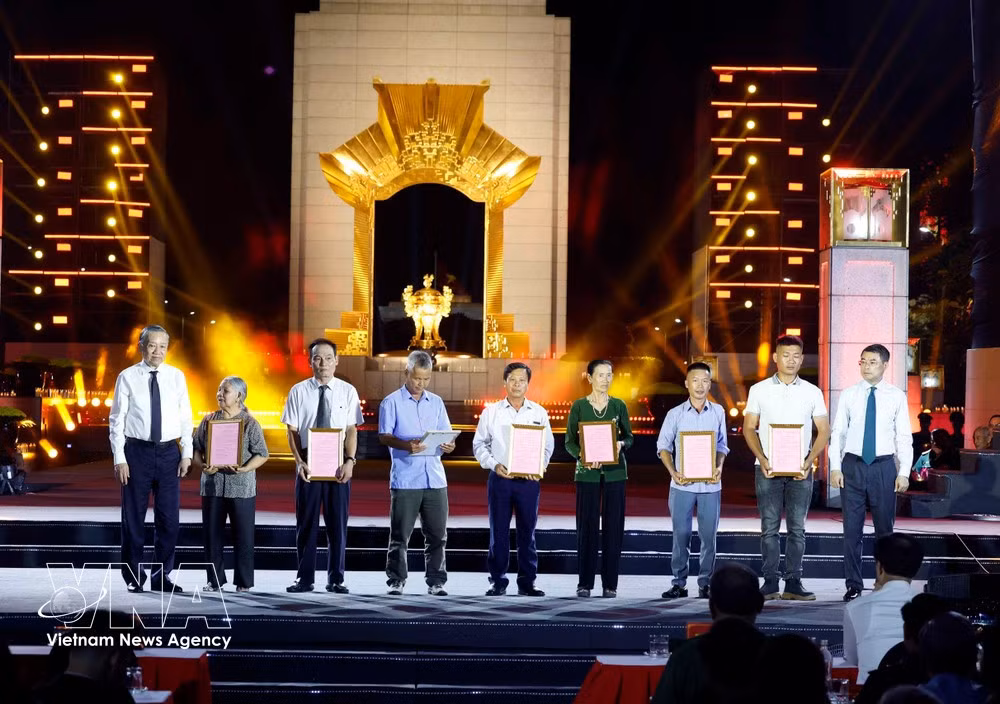 Party General Secretary and President To Lam (first, left) and Prime Minister Le Minh Hung (first, right) present DNA test result certificates to relatives of fallen soldiers' families at the Hanoi venue. (Photo: VNA)