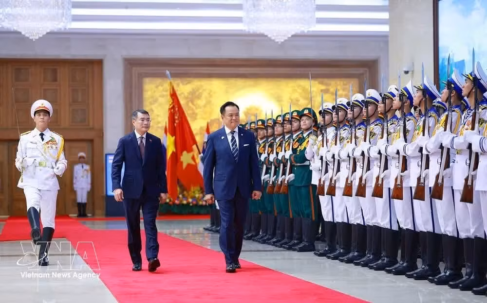 Prime Minister Le Minh Hung (left) and his Thai counterpart Anutin Charnvirakul review the Guard of Honour of the Vietnam People's Army at the welcome ceremony on June 8. (Photo: VNA)