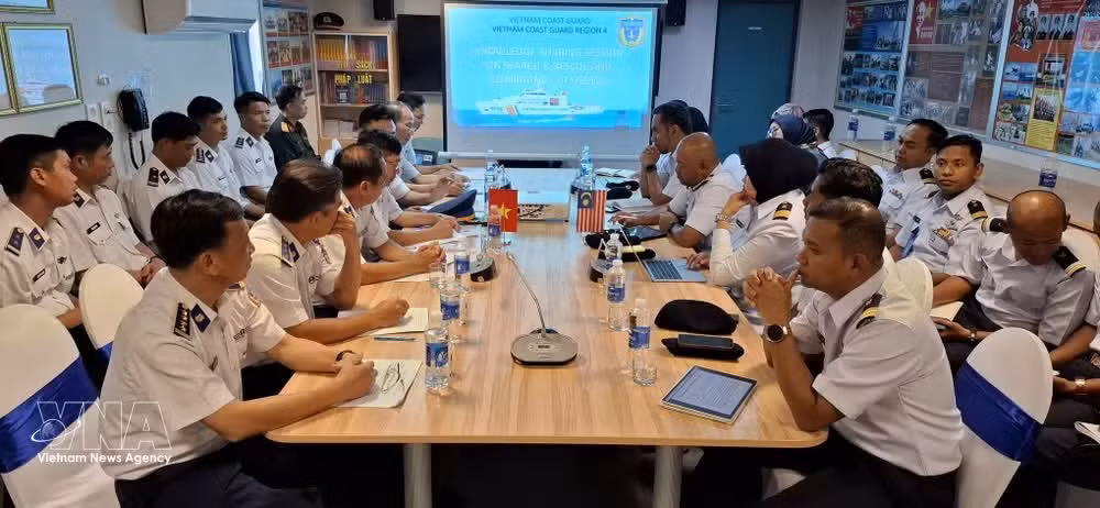Representatives of the Malaysia Maritime Enforcement Agency (MMEA) and the Vietnam Coast Guard exchange views on efforts to combat illegal, unreported and unregulated (IUU) fishing. (Photo: VNA)