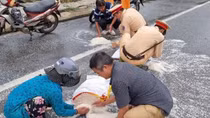 Traffic police help people clean up rice spilled over on the road