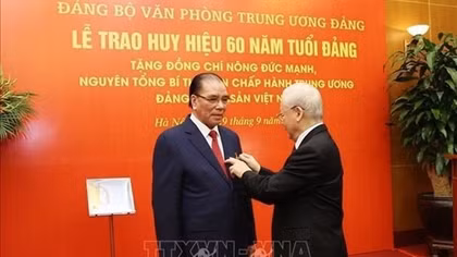 60-year Party membership badge presented to former Party chief Nong Duc Manh
